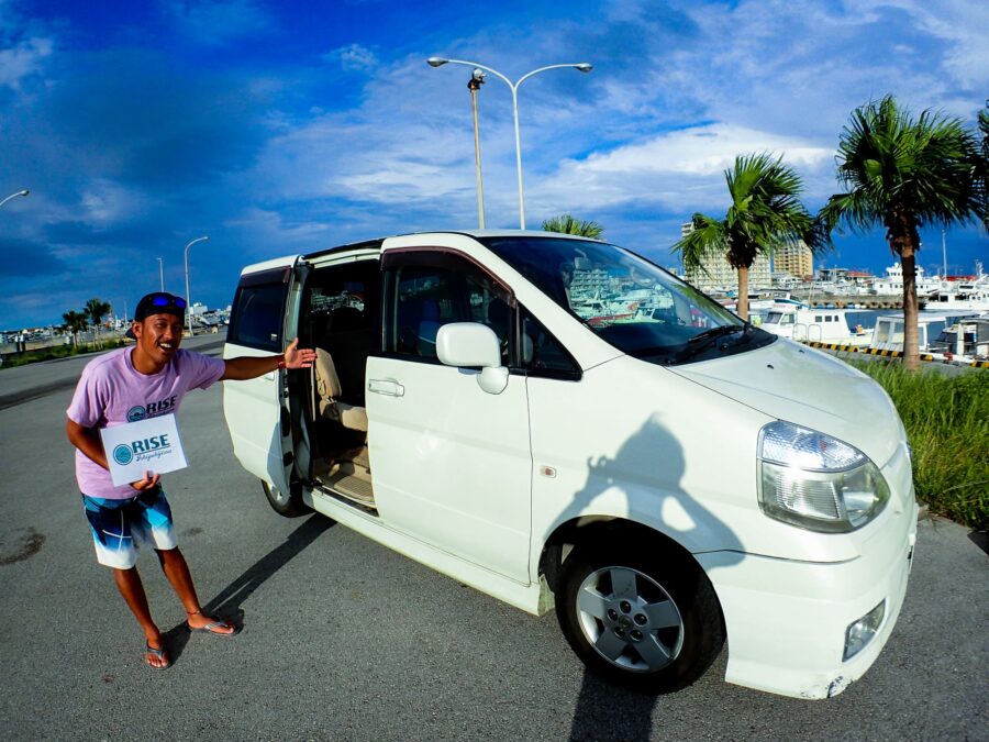 送迎車の前でガイドがお客様をお迎えする画像